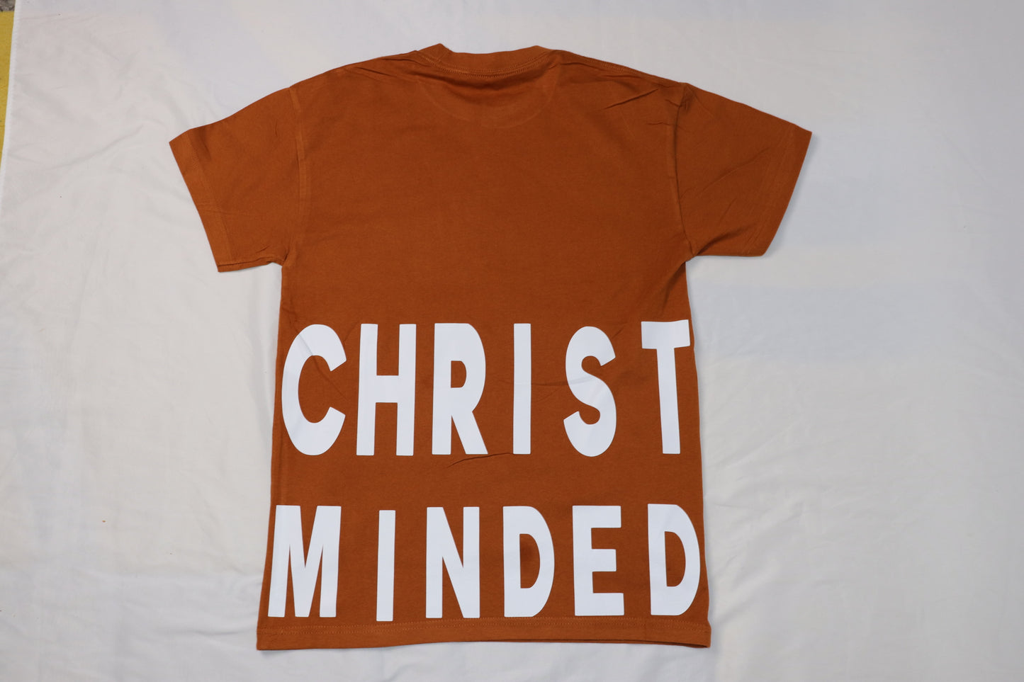 Christ Minded burnt clay t-shirt back with bold white block letters reading Christ Minded across the lower back