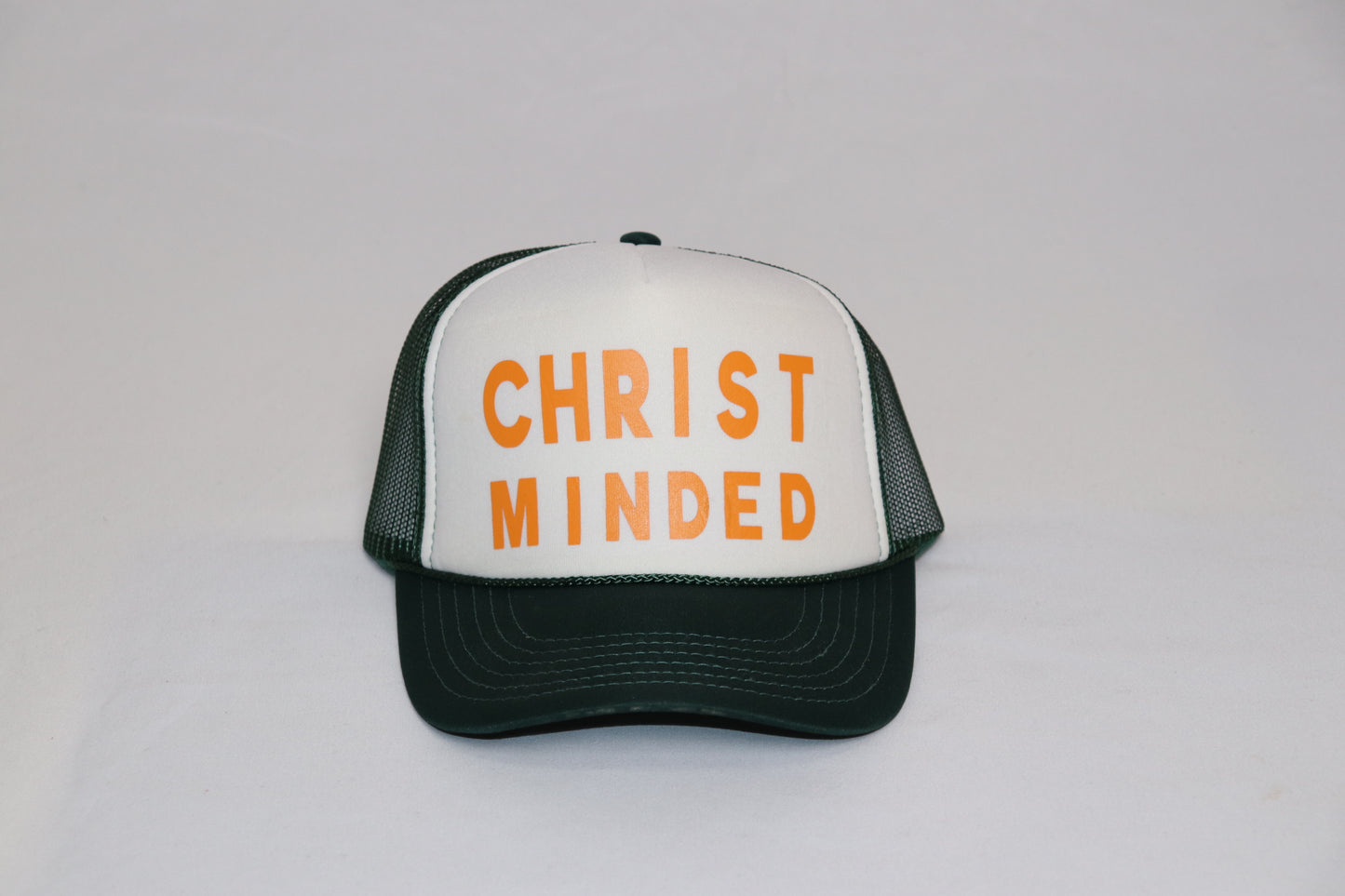 Christ Minded black and white trucker hat with bright orange faith-inspired lettering across the front panel.