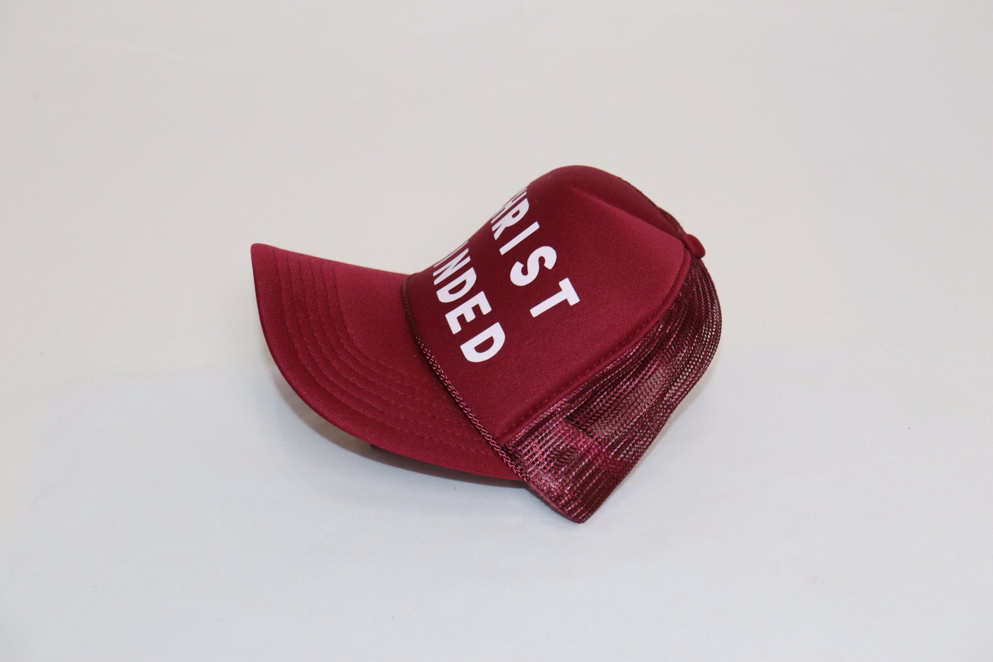 Burgundy Christian trucker hat with “Christ Minded” in white bold letters, symbolizing grace and devotion.