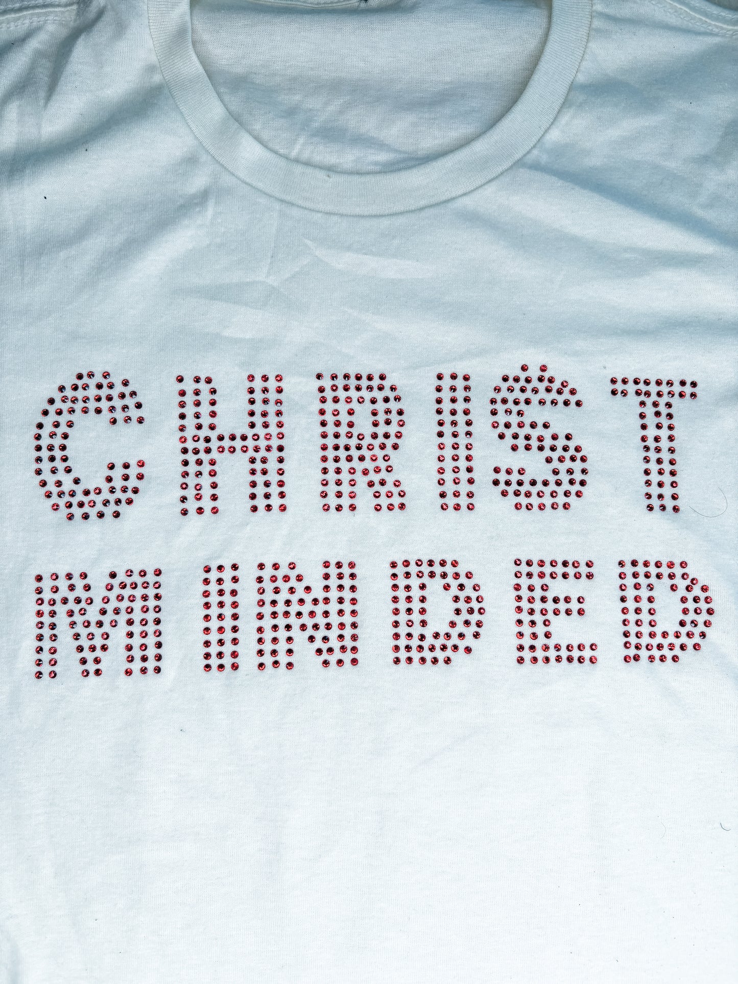 Cream t-shirt with red rhinestone lettering that reads "Christ Minded" displayed flat