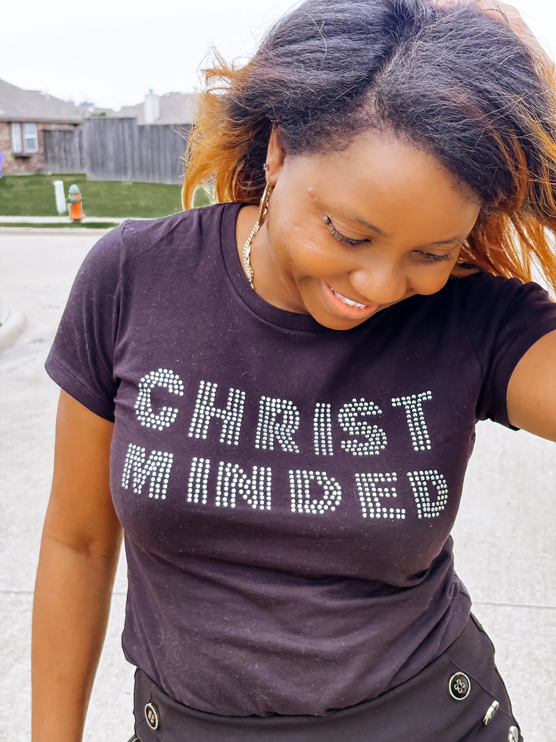 Smiling boy holding up a gray Christ Minded sweatshirt while wearing matching sweatpants