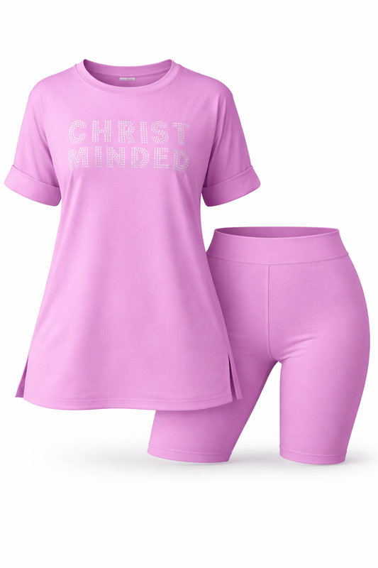 Woman smiling wearing a pink “Christ Minded” rhinestone shirt and matching shorts set