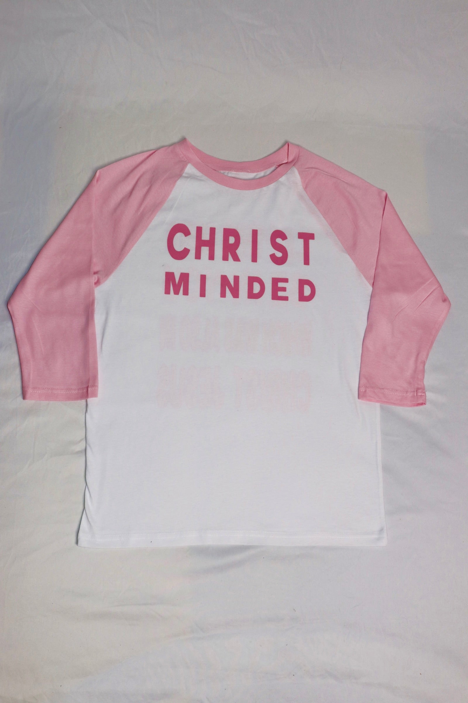 Christian baseball tee with pink sleeves and white body featuring bold “Christ Minded” design on front