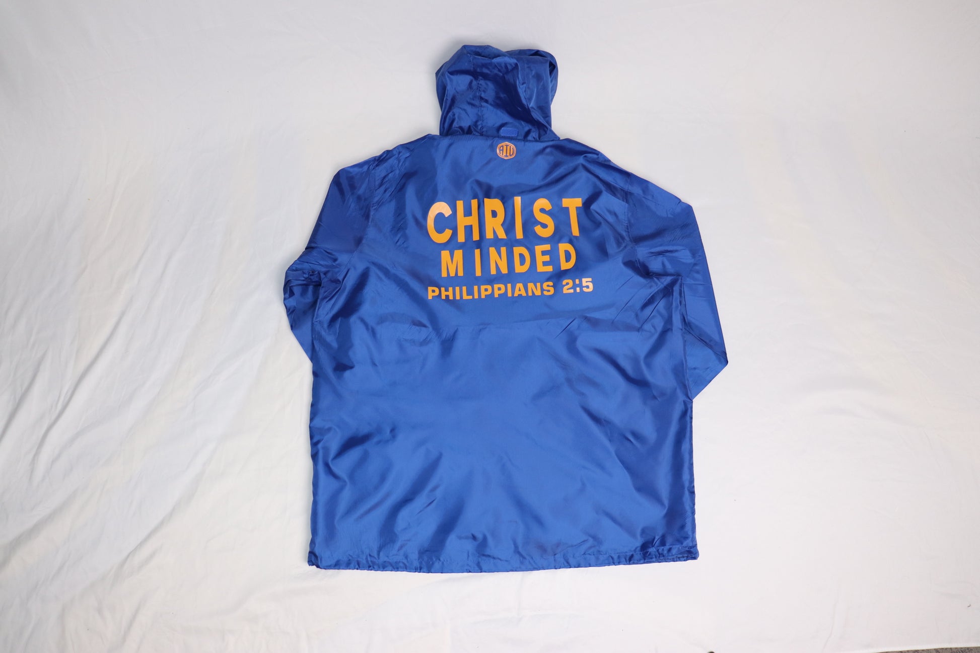 Blue Christ Minded windbreaker with yellow Philippians 2:5 scripture printed on the back