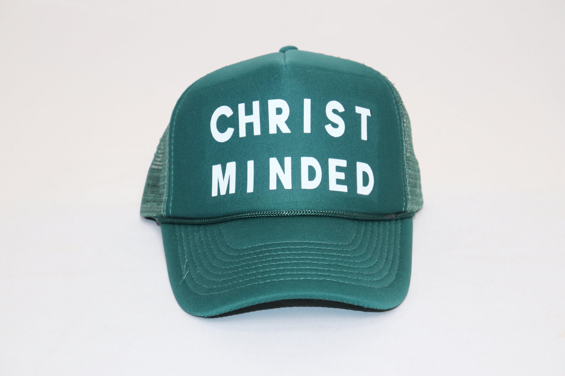 Green Christ Minded trucker hat with white bold lettering on the front mesh panel